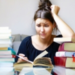 College student busy with stacks of books