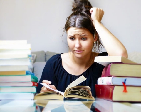 College student busy with stacks of books