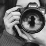 Person holding a camera up looking into lense