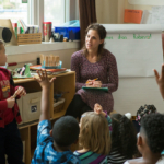 woman in purple dress teaching elementary class