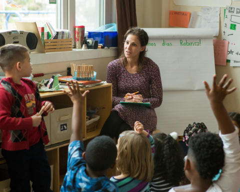 woman in purple dress teaching elementary class