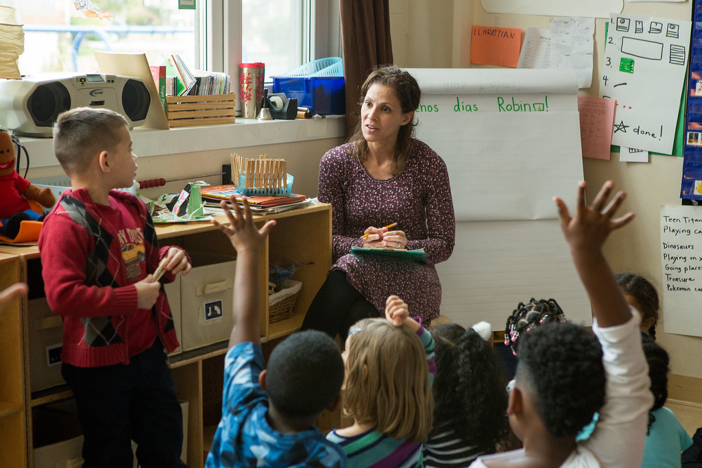 woman in purple dress teaching elementary class