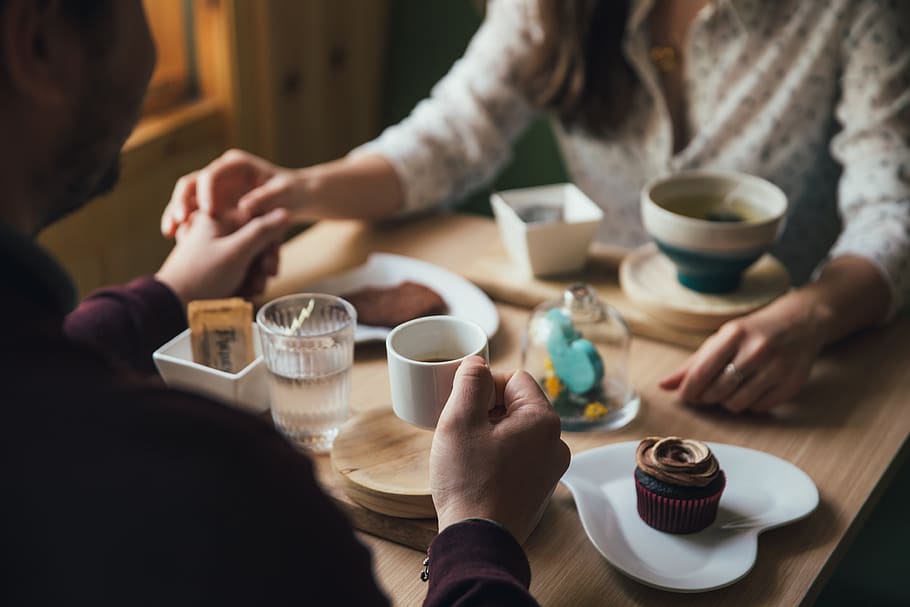 Two people hold hands getting coffee